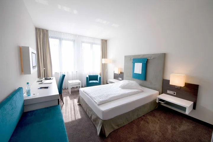 Einzelzimmer Superior mit Queen-Size-Bett und blauem Sessel
